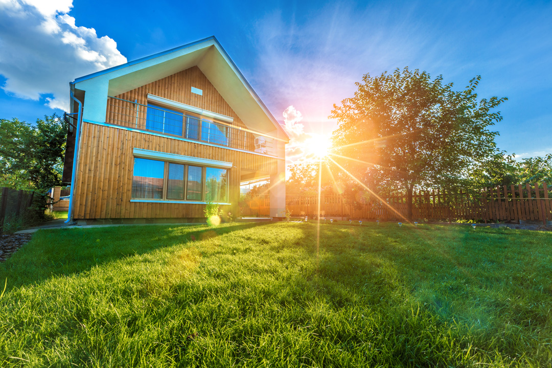 Modern summer cottage against a blue sky in the summer garden soins-energetique